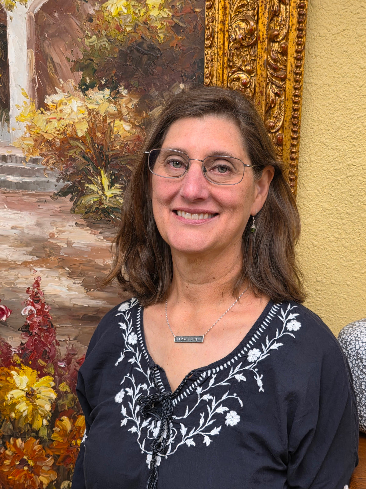 picture of woman with long brown hair in front of painting